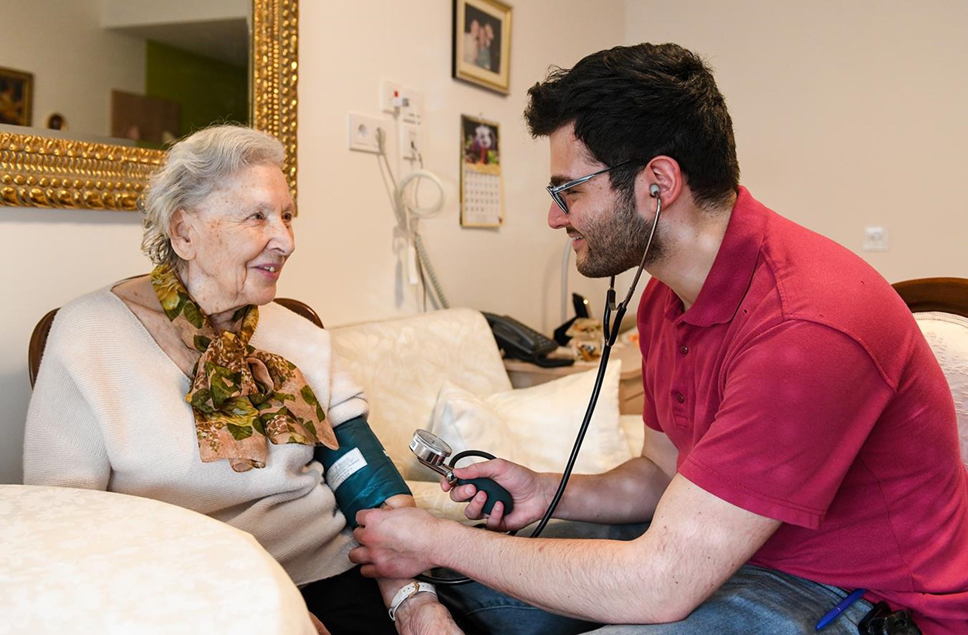 junger Pfleger beim Blutdruckmessen