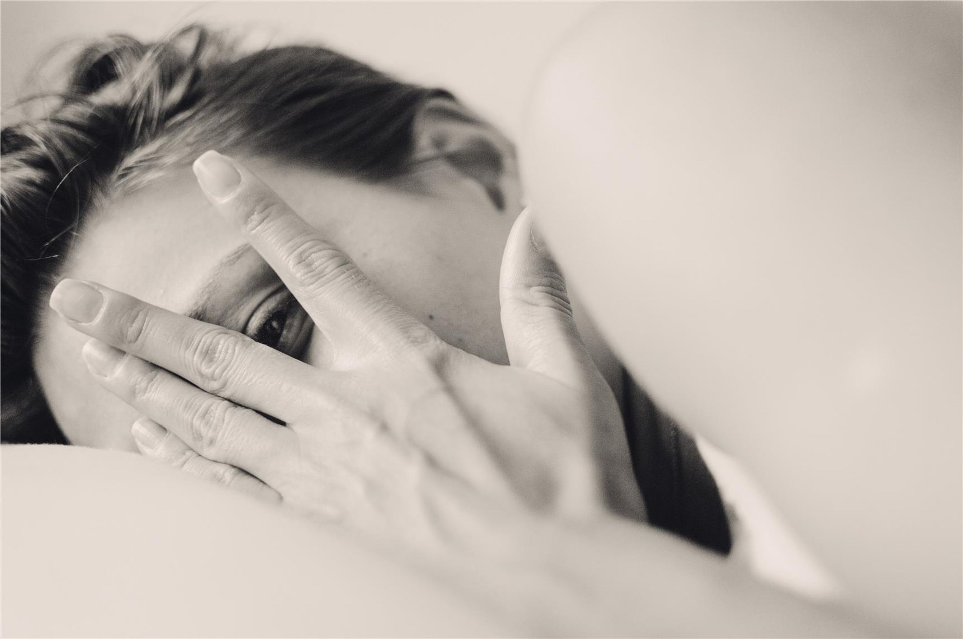 Frau hält Hand vor das Gesicht