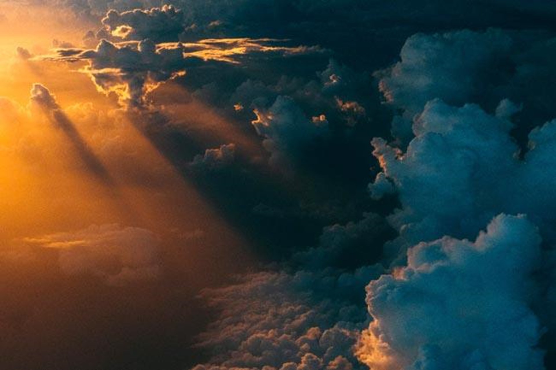 dunkle Gewitterwolken werden von Sonne durchbrochen